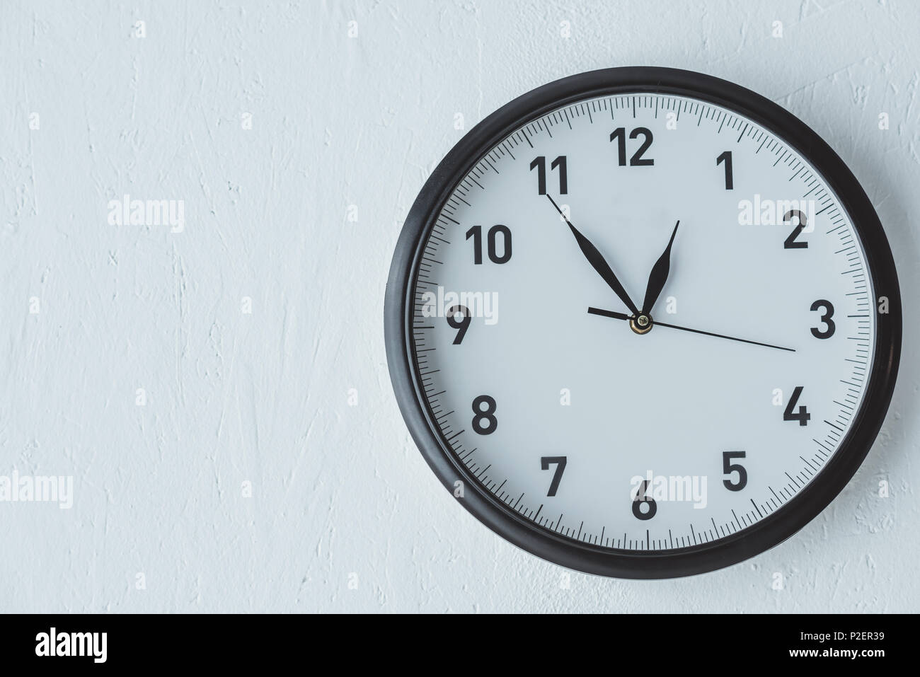 black clock on white wall with copy space Stock Photo Alamy