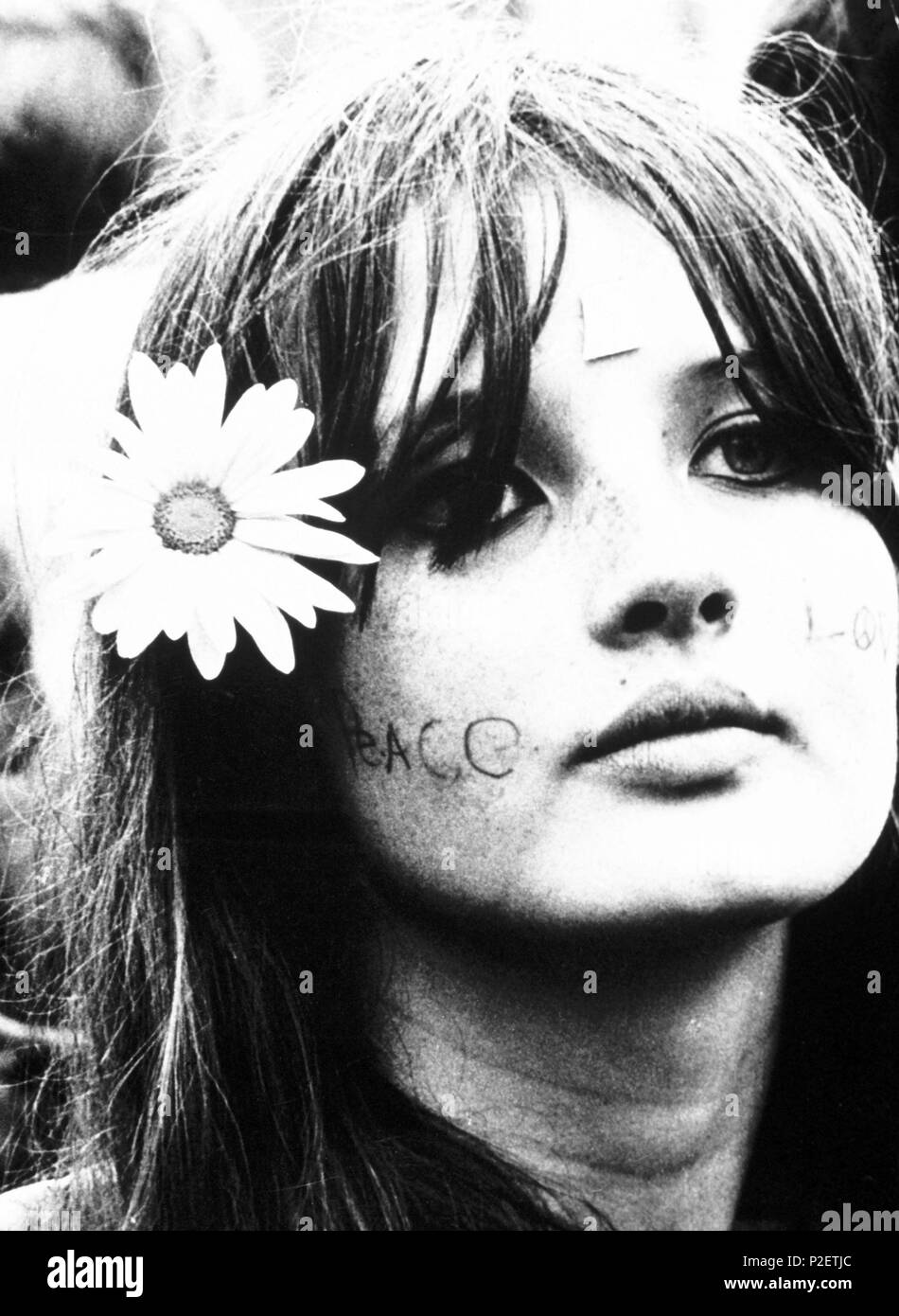 A hippie girl with "Peace" and "Love" writtenon her cheeks Stock Photo