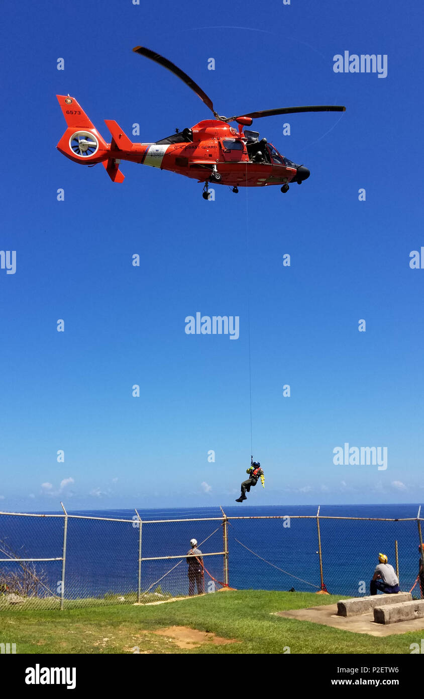 Coast Guard helicopter crews conducted cliff and vertical surface rescue training Sept. 15, 2016, near Air Station Borinquen, 200 feet above Survivor Beach, in Aguadilla, as part of crew certification requirements to conduct search and rescue operations in Puerto Rico and the U.S. Virgin Islands. (U.S. Coast Guard photo by Lt. Matt Udkow, Air Station Borinquen MH-65 Dolphin helicopter pilot). Stock Photo
