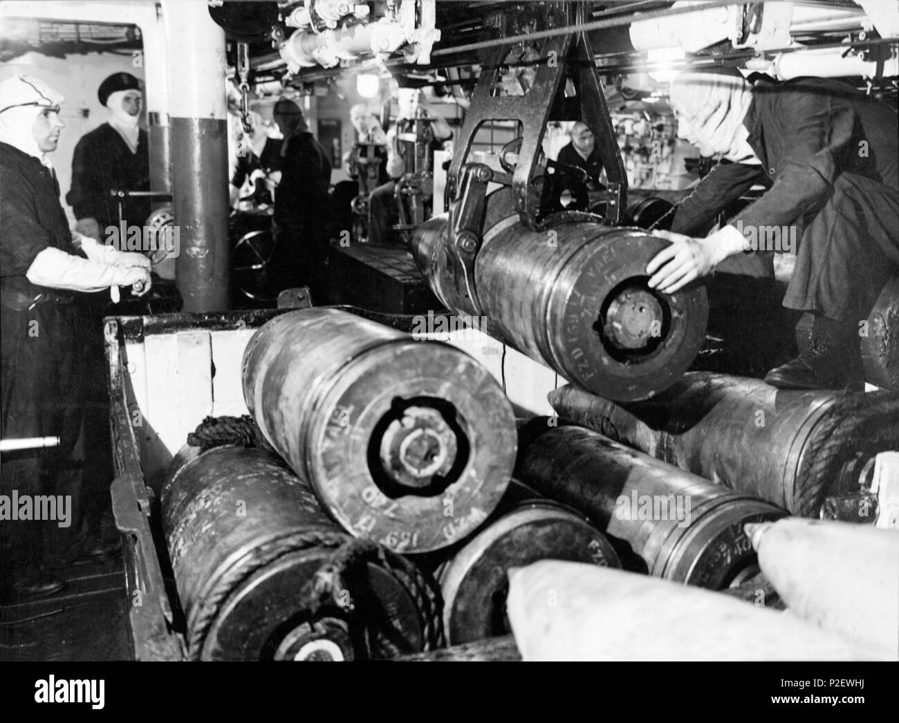 In the shell room of a battleship of the Queen Elizabeth class, 15' projectiles being handled by a mechanical grip. Stock Photo