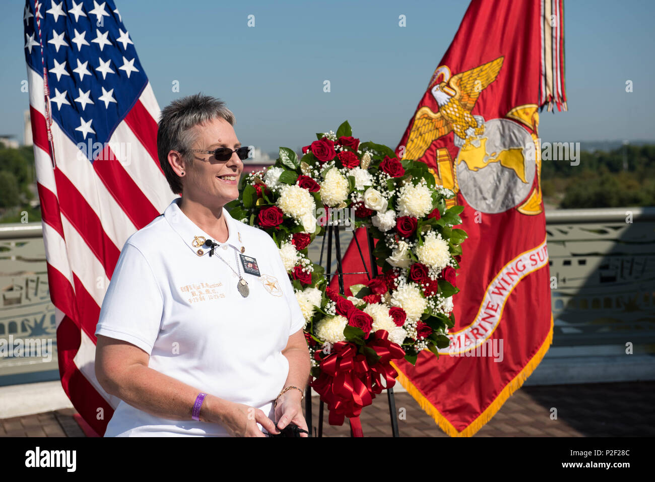 Jana Rigsby stands next to the American flag and Marine Corps battle standard for any interview following a wreath-laying ceremony in Nashville, Tenn. Sept. 7, 2016, as part of Marine Week. The wreath-laying ceremony was to honor Rigsby, a gold-star mother, who lost her son Lance Cpl. Tyler R. Overstreet in 2006. Marine Week Nashville is an opportunity for the people of the greater Nashville area to meet Marines and learn about Corps’ history, traditions and value to the nation. (Official Marine Corps photo by Lance Cpl. Timothy Smithers/ Released) Stock Photo