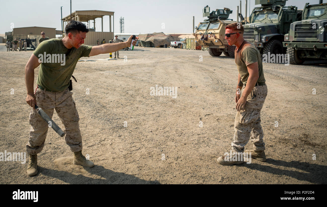 U.S. Marine Corps Lance Cpl. Albert Huerta (left), a radio operator with Detachment N, 3rd Air Naval Gunfire Liaison Company, Special Purpose Marine Air-Ground Task Force - Crisis Response - Central Command 16.2, contaminates Cpl. Brandon Ashker, a military policeman with Law Enforcement Detachment, SPMAGTF-CR-CC 16.2, with inert Oleoresin Capsicum spray during an OC qualification course at an undisclosed location in Southwest Asia, Aug. 27, 2016. SPMAGTF-CR-CC is a self-sustaining expeditionary unit, designed to provide a broad range of crisis response capabilities. (U.S. Marine Corps photo b Stock Photo