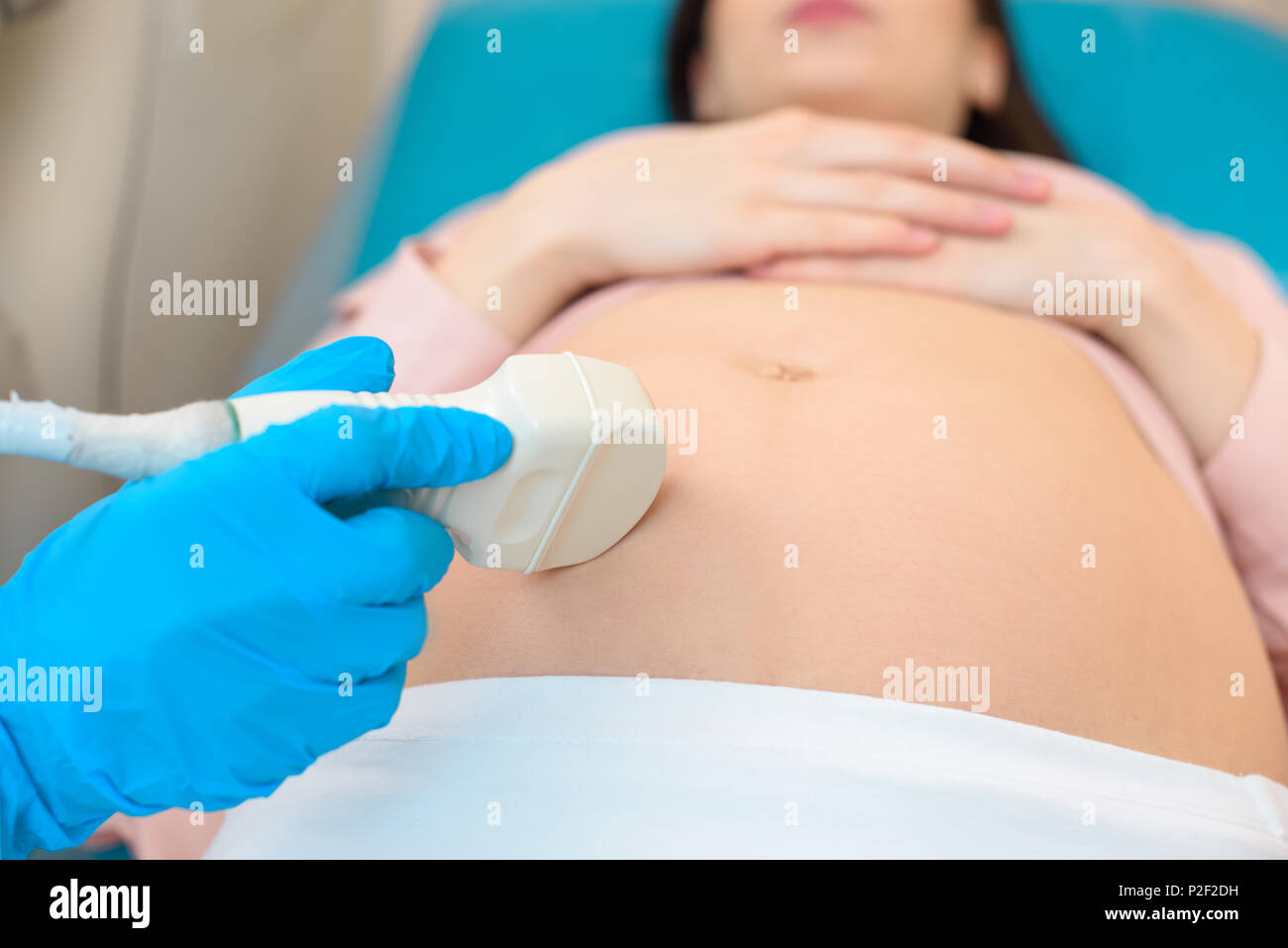 close-up shot of obstetrician gynecologist making of ultrasound examination pregnant woman Stock Photo