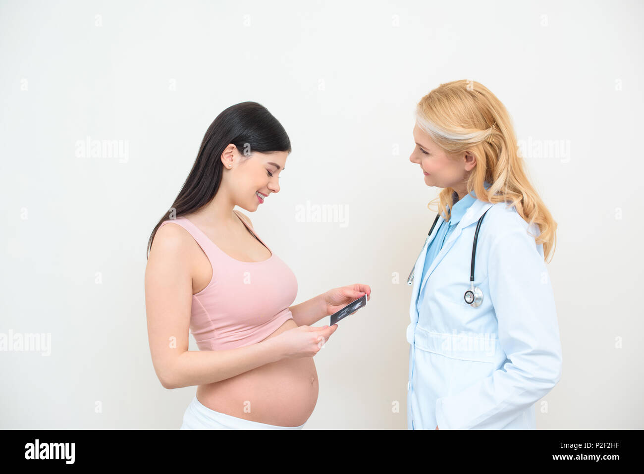 mature obstetrician gynecologist and pregnant woman with ultrasound scan picture Stock Photo