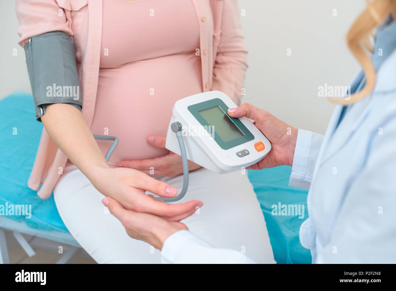 cropped shot of obstetrician gynecologist measuring blood pressure of pregnant woman at clinic Stock Photo