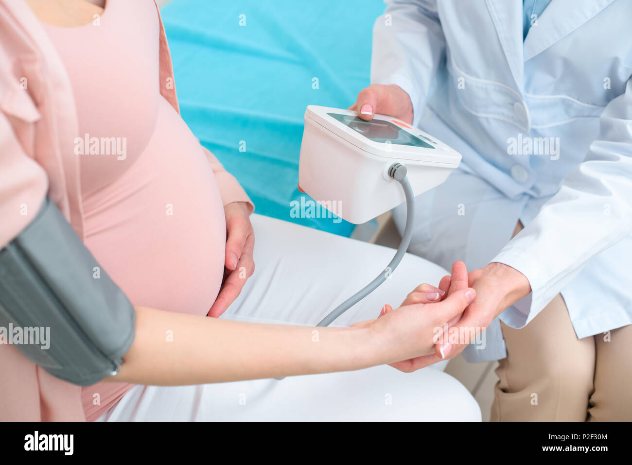 cropped shot of obstetrician gynecologist measuring blood pressure of pregnant woman Stock Photo