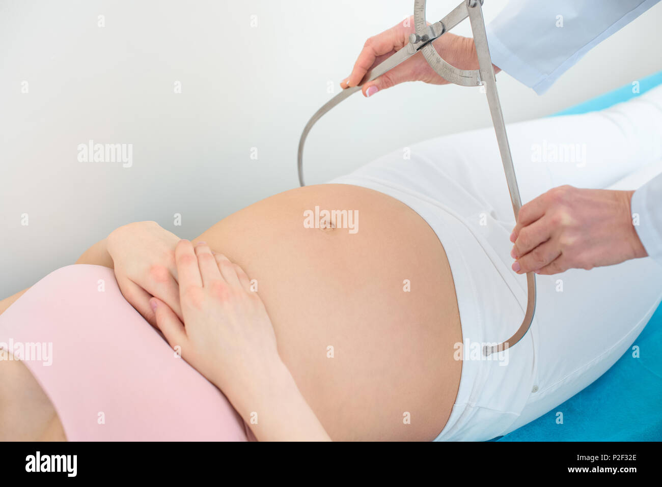 cropped shot of obstetrician gynecologist measuring pelvis size of ...