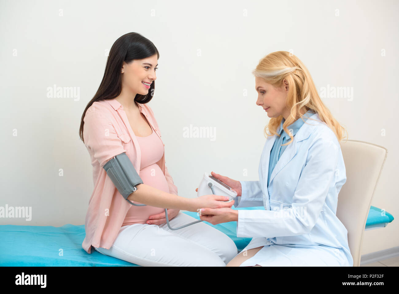 obstetrician gynecologist measuring blood pressure of pregnant woman Stock Photo