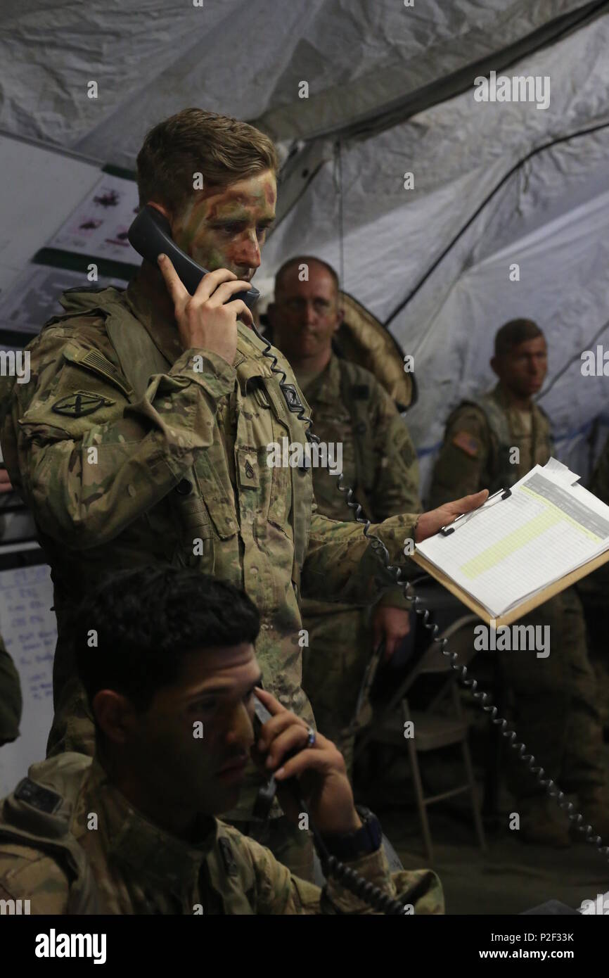 U.S. Army Staff Sgt. Brian Fisher, center of 1st Battalion, 41st Field Artillery Regiment, 1st Armored Brigade receives mission updates while managing a tactical operations center during exercise Combined Resolve VII at the U.S. Army’s Joint Multinational Readiness Center in Hohenfels Germany, Sept. 7, 2016. Combined Resolve VII is a 7th Army Training Command, U.S. Army Europe-directed exercise, taking place at the Grafenwoehr and Hohenfels Training Areas, Aug. 8 to Sept. 15, 2016. The exercise is designed to train the Army’s regionally allocated forces to the U.S. European Command. Combined R Stock Photo