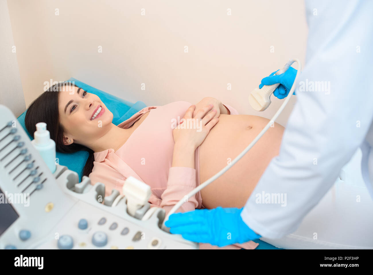 obstetrician gynecologist making ultrasound scanning for young happy pregnant woman Stock Photo