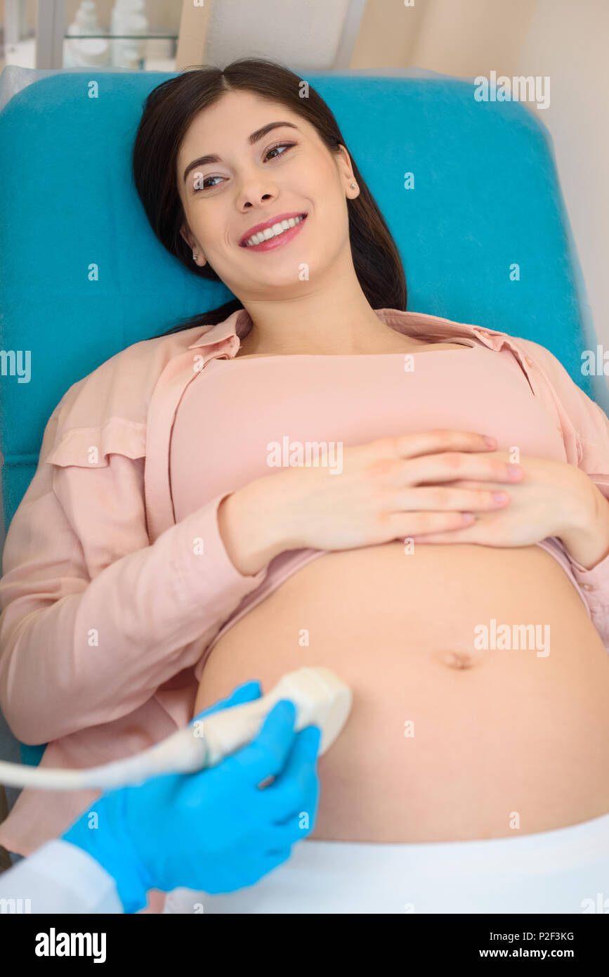 obstetrician gynecologist making ultrasound examination for smiling pregnant woman Stock Photo