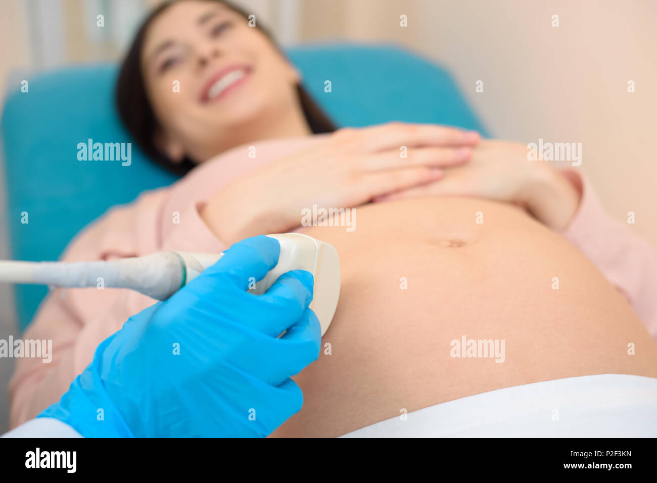 close-up shot of obstetrician gynecologist making ultrasound examination for pregnant woman Stock Photo