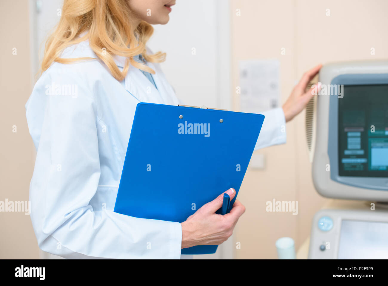 cropped shot of doctor with clipboard touching ultrasonic scanner Stock Photo