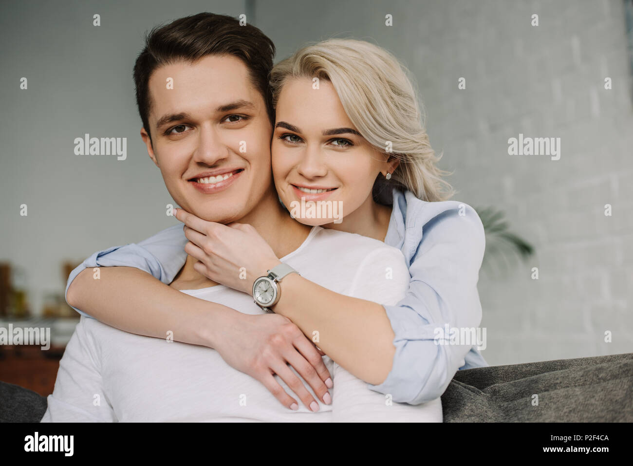smiling couple hugging and looking at camera Stock Photo - Alamy