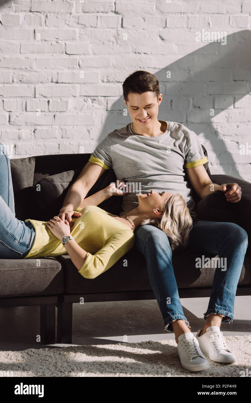 happy girlfriend lying on boyfriends legs in living room at home Stock  Photo - Alamy