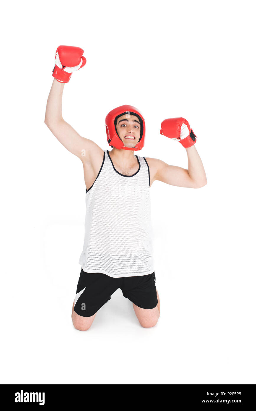 Young skinny boxer in helmet and gloves standing on knees isolated on white Stock Photo