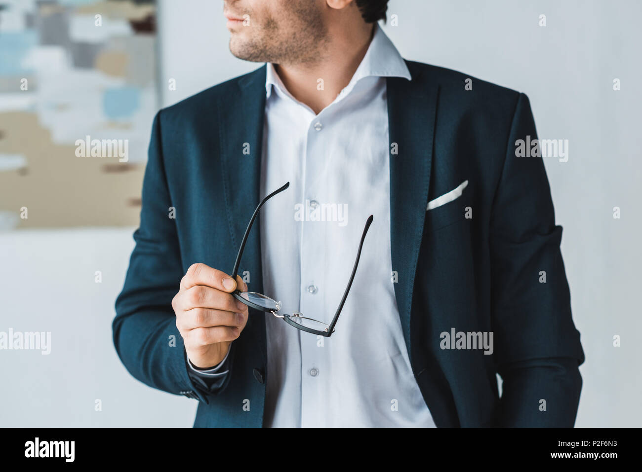 Businessman wearing suit and holding glasses in his hand Stock Photo ...