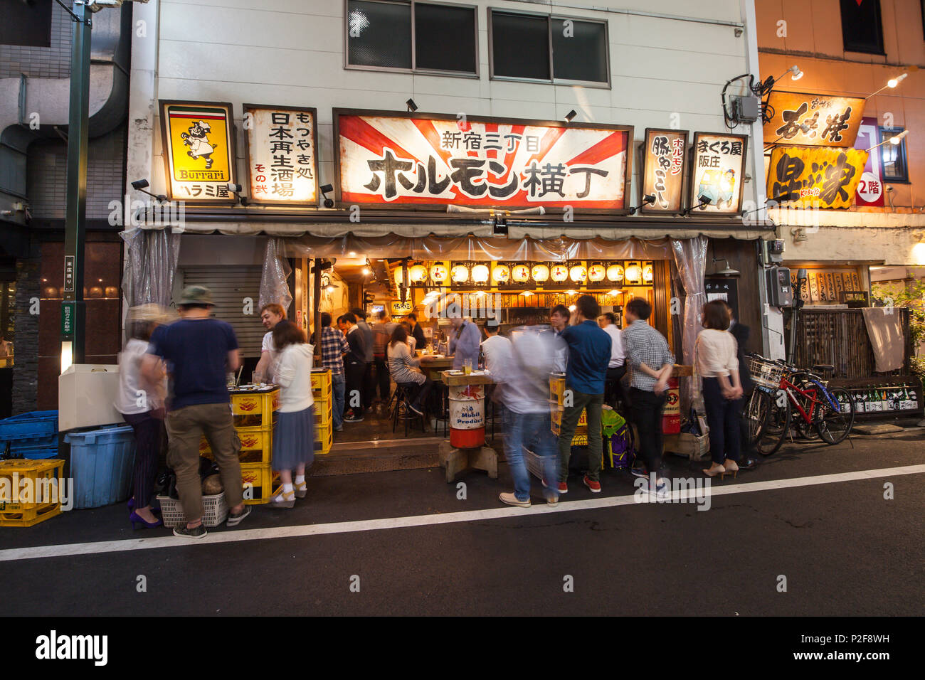 Japanese Izakaya at evening with young people enjoying eating and drinking together, Shinjuku, Tokyo, Japan Stock Photo
