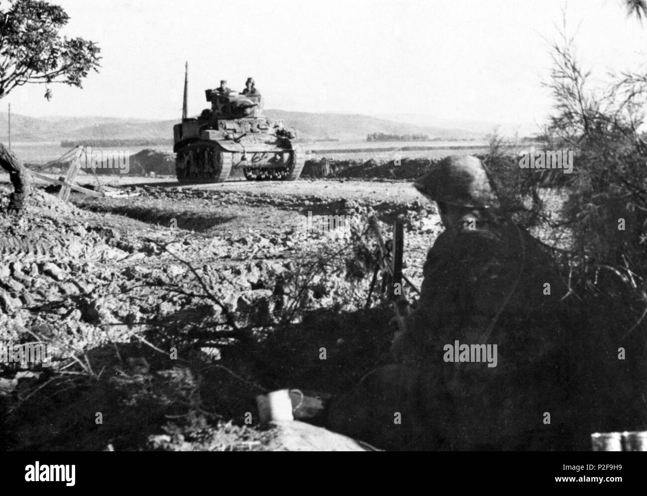 American light tank returning after the battle. Bren gunner in fore ground is covering the road. WWII, December 1942. Stock Photo