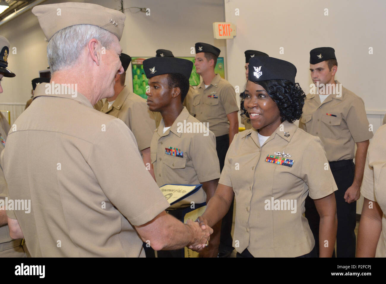 Damage Controlman 1st Class Fungai Diura shakes hands with Vice Adm