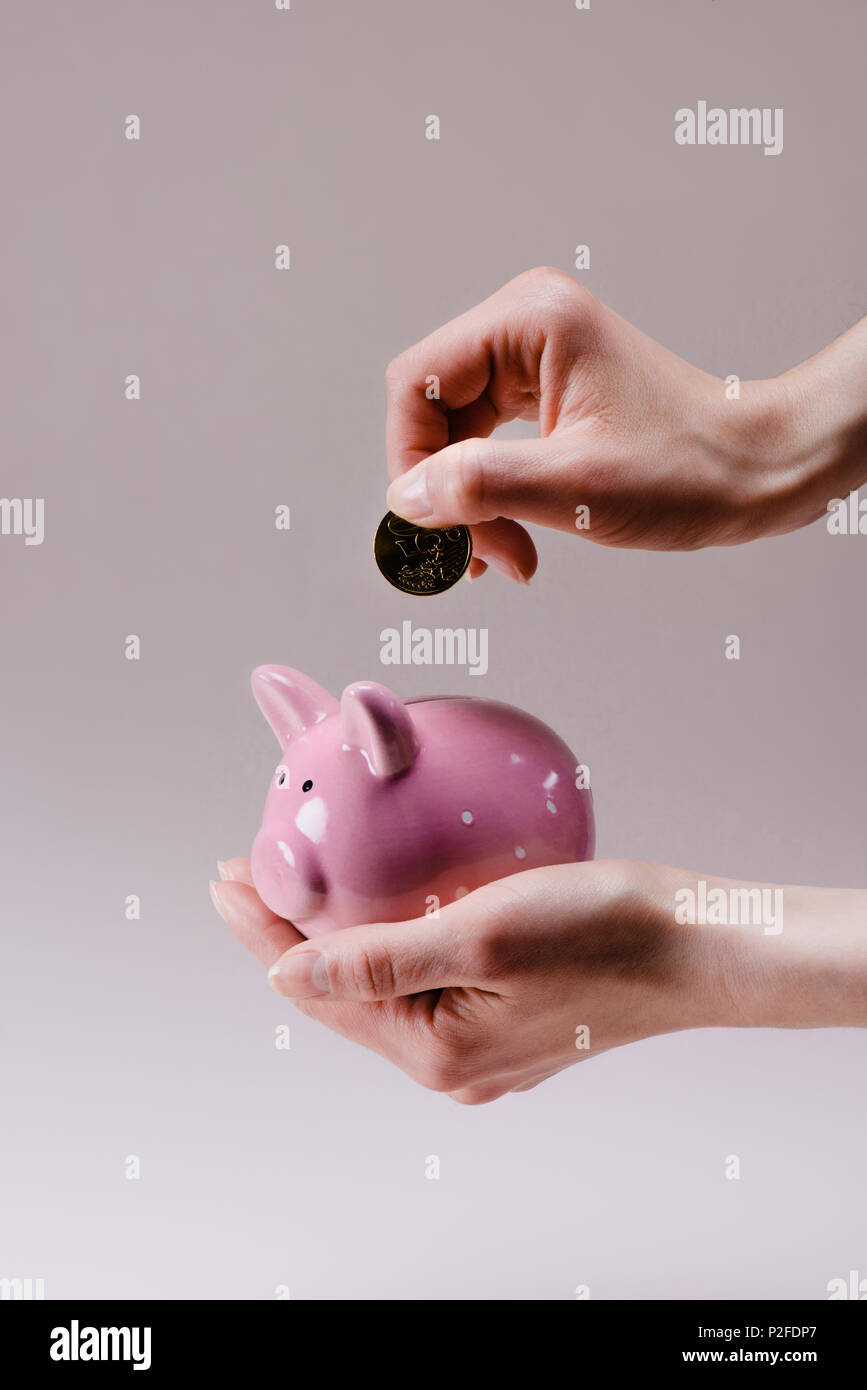 Cropped Shot Of Woman Putting 50 Euro Cent Into Pink Piggy Bank In