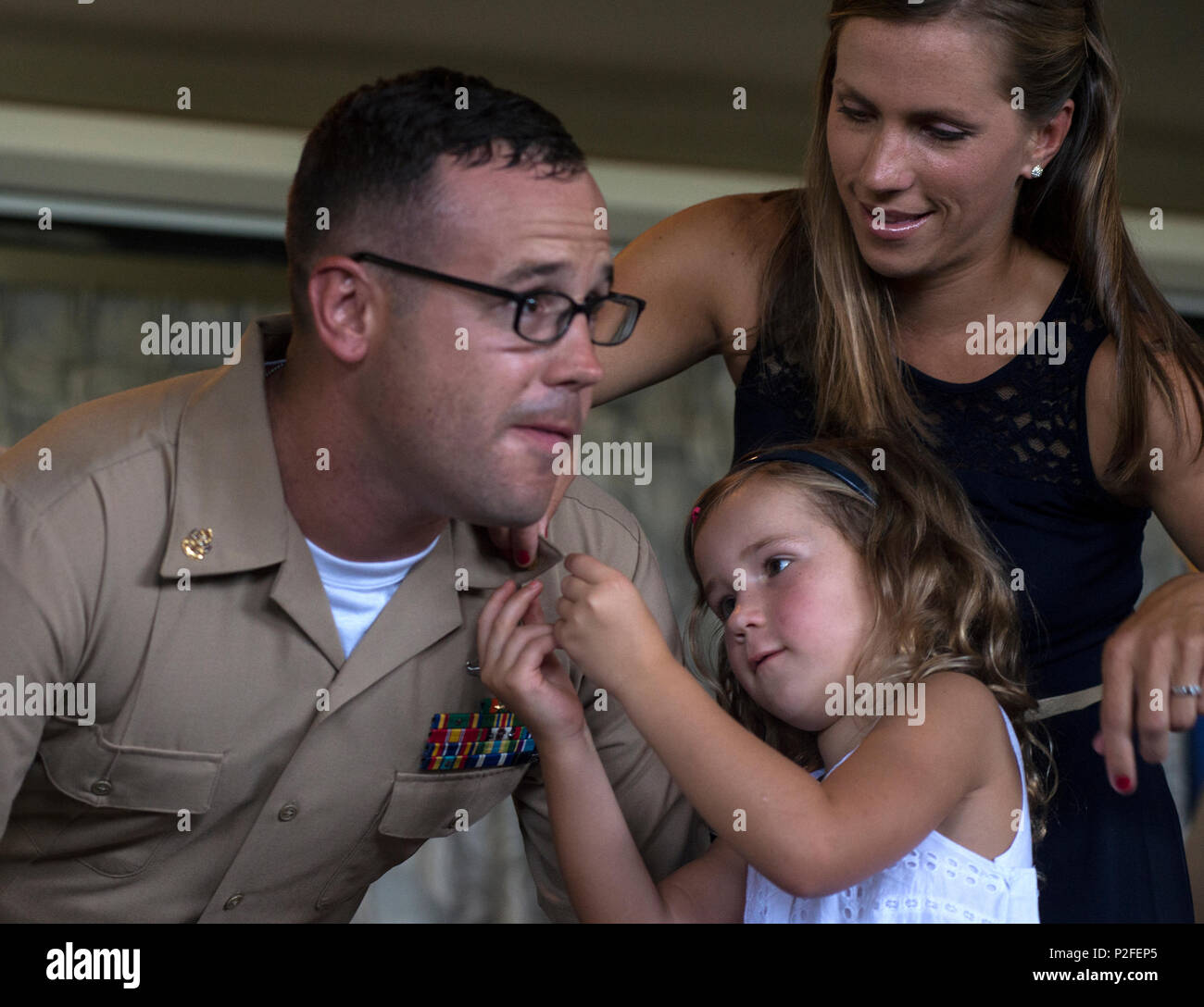160916-N-GI544-487 PEARL HARBOR (Sept. 16, 2016) Chief Hospital Corpsman Adrian Adamson is pinned by his family during a chief pinning ceremony at Hickam Officer's Club Lanai, Joint Base Pearl Harbor-Hickam. The chief pinning ceremony is part of a long-standing tradition that honors and recognizes the years of hard work, service and leadership of dedicated Sailors in the Navy. As part of their new responsibility, new chiefs are expected to guide their junior Sailors and uphold the legacy of the chief petty officer. (U.S. Navy photo by Mass Communication Specialist 2nd Class Laurie Dexter/Relea Stock Photo