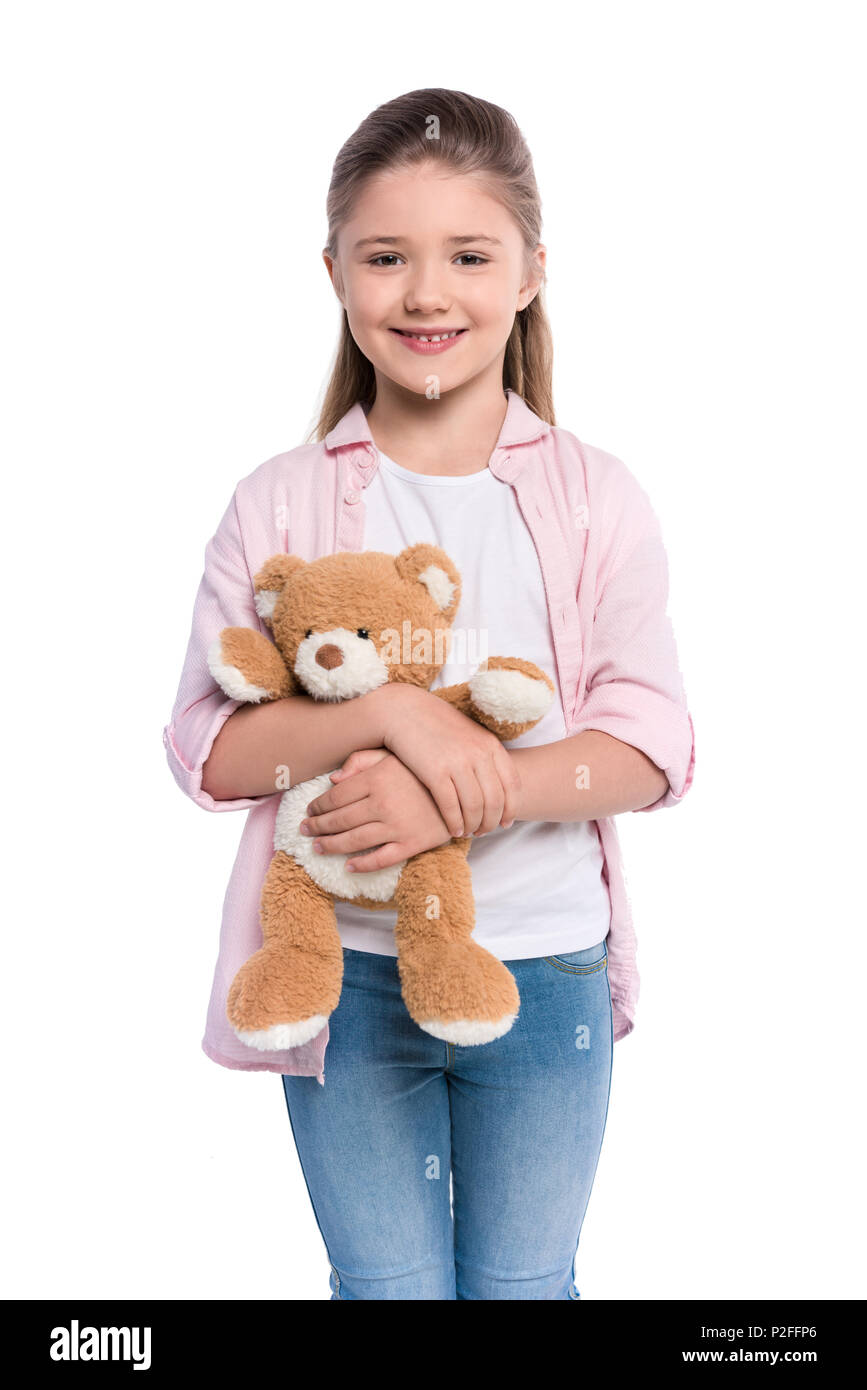 Half-length shot of a smiling little girl holding a teddy bear and ...