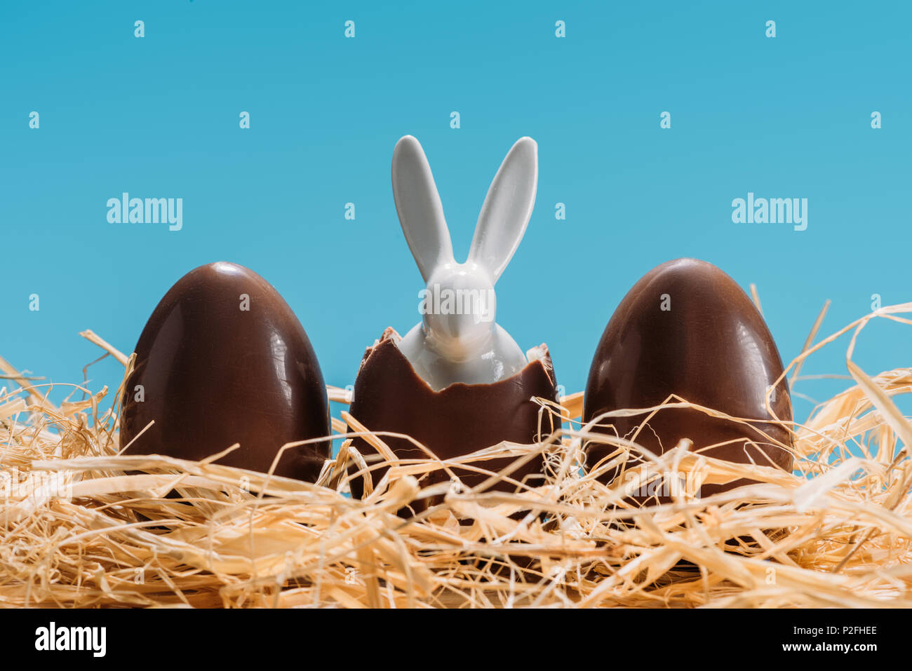 easter bunny in chocolate eggs on straw isolated on blue Stock Photo
