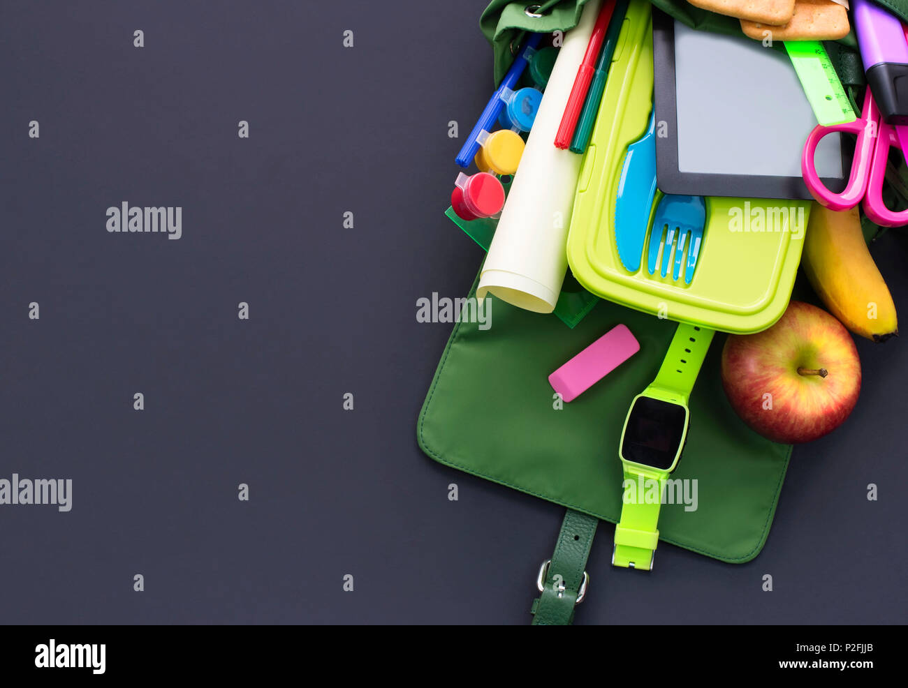 Backpack with school supplies on black background. Top view Flat lay Stock Photo