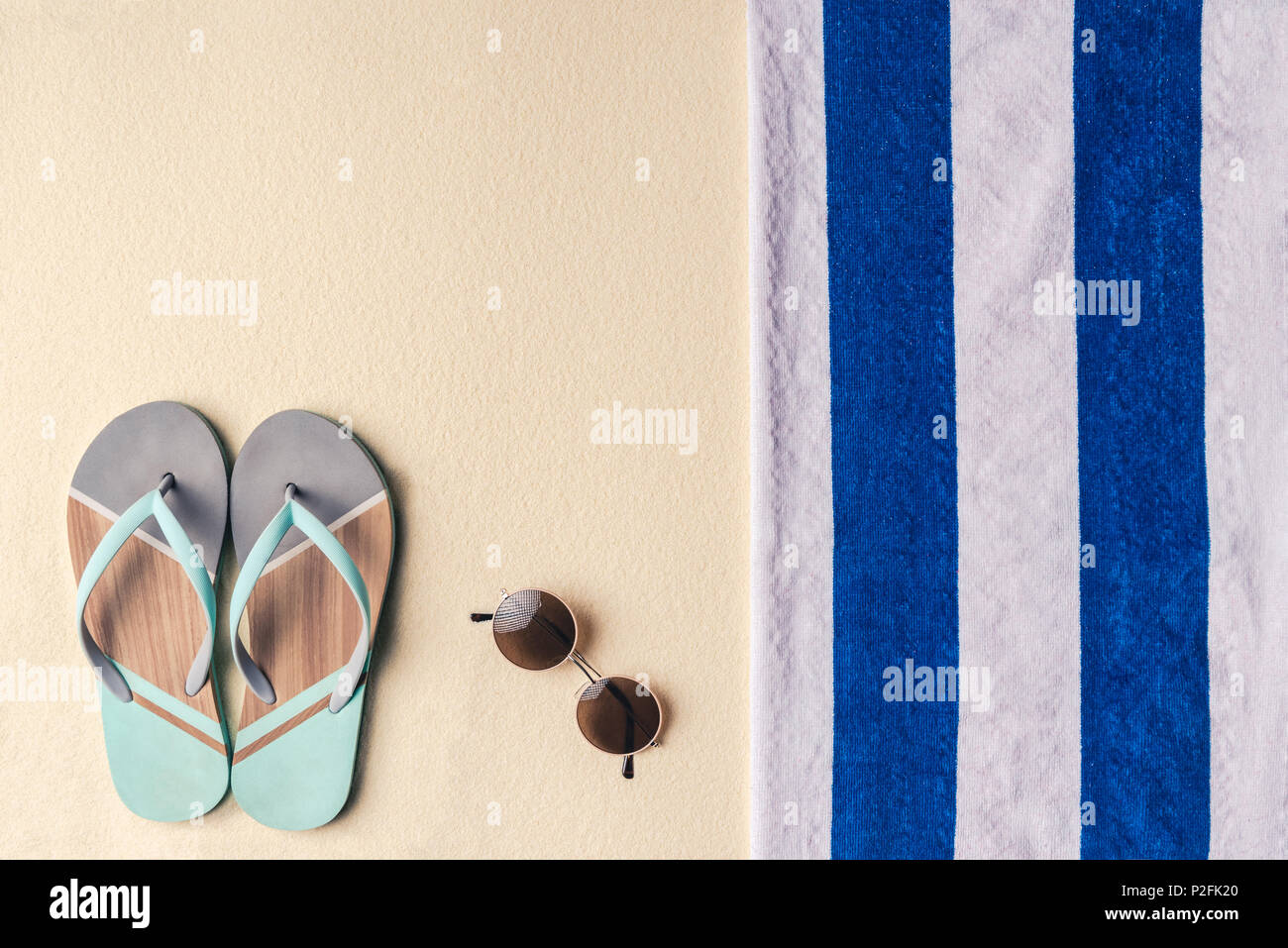 Flip flops and sunglasses by towel on sandy beach Stock Photo - Alamy