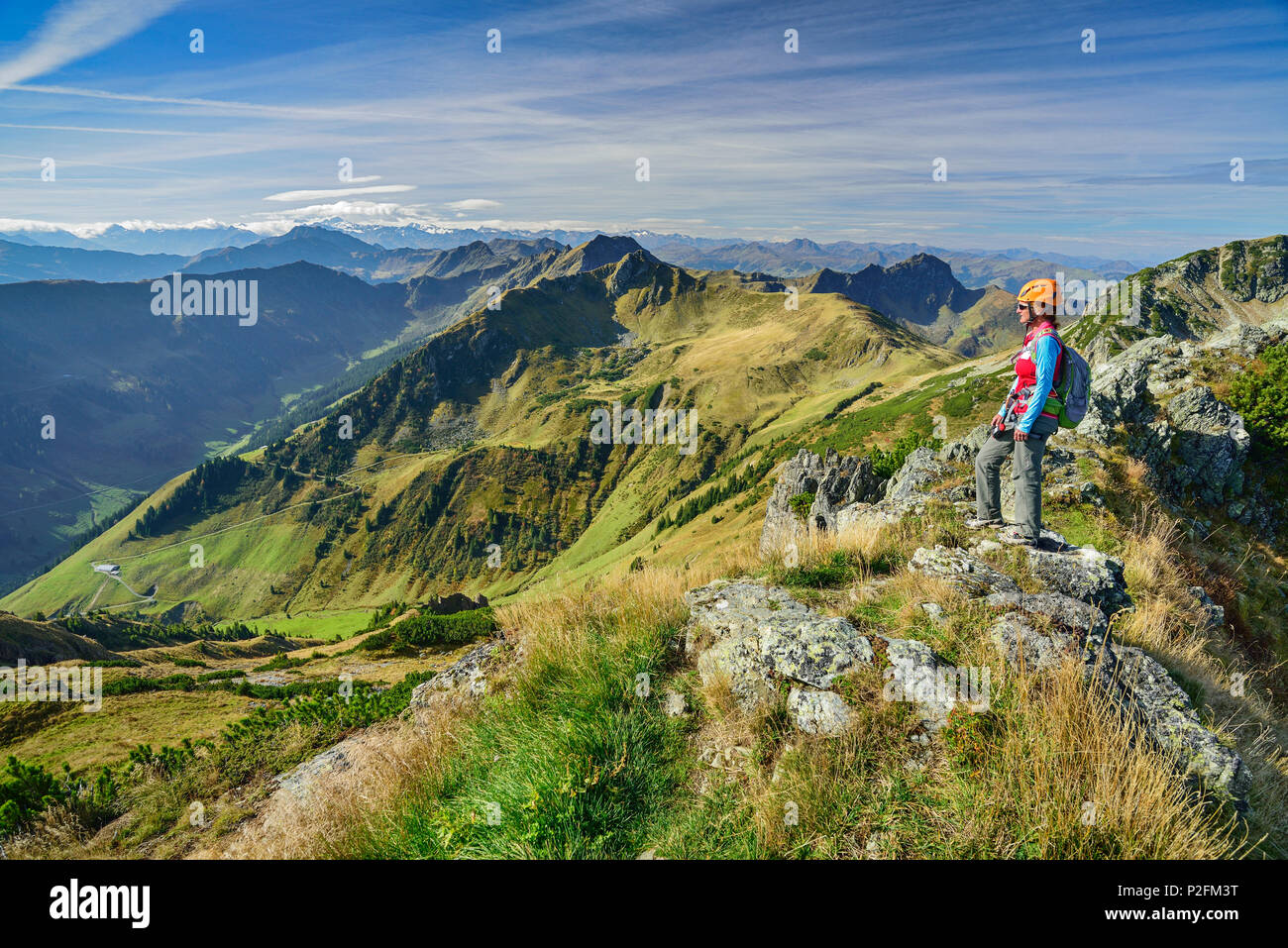Woman ascending ridge towards Henne, fixed rope route Henne, Henne, Kitzbuehel range, Tyrol, Austria Stock Photo