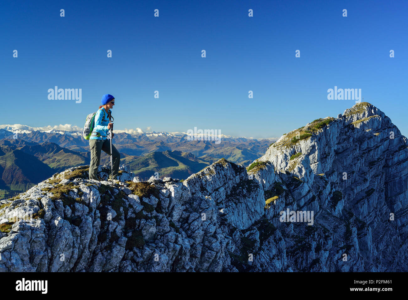 Woman hiking on ridge with Grossvenediger in background, Nurracher Hoehenweg, Ulrichshorn, Loferer Steinberge range, Tyrol, Aust Stock Photo