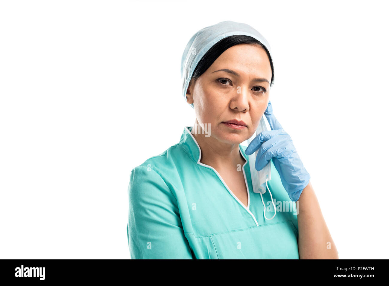 pensive female asian surgeon looking at camera isolated on white Stock ...