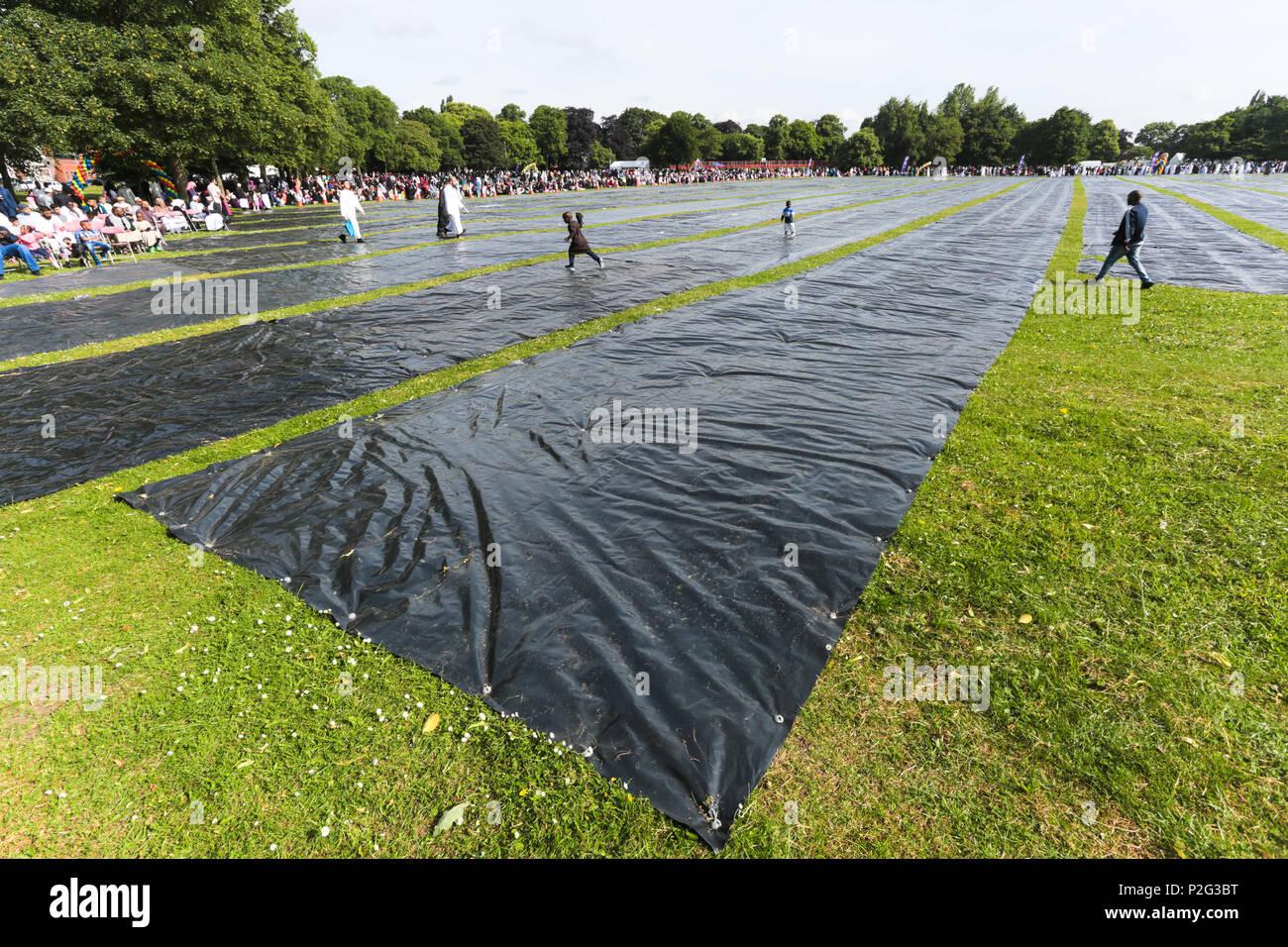 Birmingham, UK. 15th June, 2018. Over 100,000 muslims gather in Small Heath park, Birmingham, to pray on the morning of Eid, the end of the fasting month of Ramadan. Plastic sheeting is laid in place of prayer mats. Peter Lopeman/Alamy Live News Stock Photo