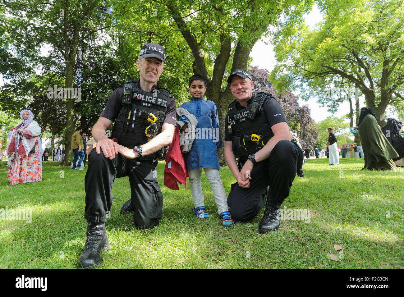 Birmingham, UK. 15th June, 2018. Over 100,000 muslims gather in Small Heath park, Birmingham, to pray on the morning of Eid, the end of the fasting month of Ramadan. Police take time to pose with children Peter Lopeman/Alamy Live News Stock Photo