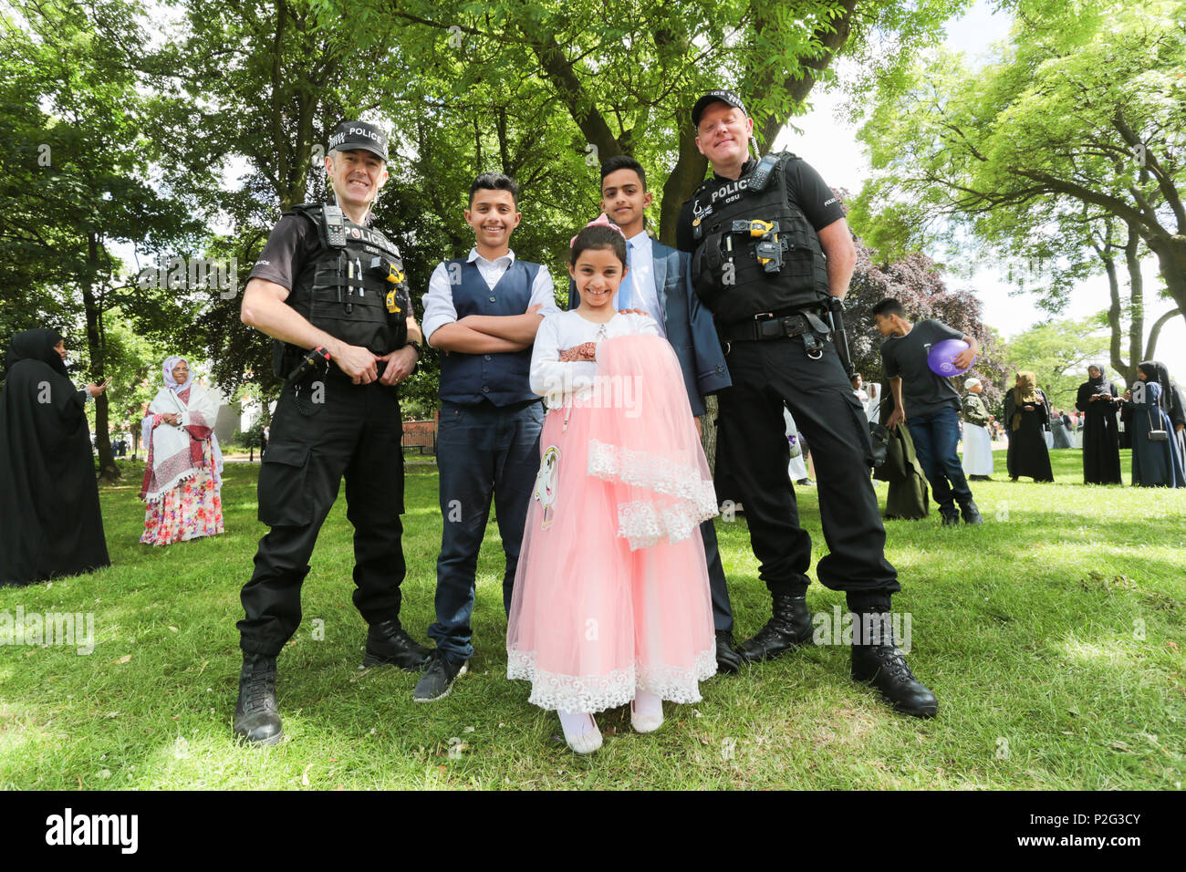 Birmingham, UK. 15th June, 2018. Over 100,000 muslims gather in Small Heath park, Birmingham, to pray on the morning of Eid, the end of the fasting month of Ramadan. Police take time to pose with children Peter Lopeman/Alamy Live News Stock Photo