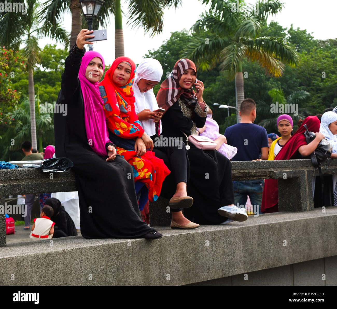 A group of Muslim women taking a selfie. Filipino and foreign Muslims gather at Quirino Grandstand in Manila to celebrate the end of Ramadan. They celebrate it with prayers, food and fun, especially for the family. Eid al-Fitr is an important religious holiday celebrated by Muslims worldwide that marks the end of Ramadan, the Islamic holy month of fasting. Stock Photo