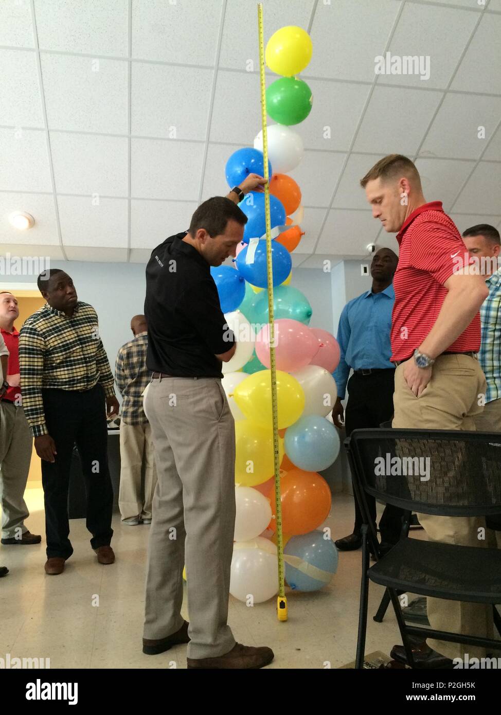 Justin Foster (center), a lead Master Resilience Trainer performance expert with Fort Campbell’s Comprehensive Soldier and Family Fitness program, measures the balloon tower of a team from 101st Airborne Division Sustainment Brigade, 101st Abn. Div. (Air Assault), during a Great Teams event Sept. 16, 2016, on Fort Campbell, Kentucky. (U.S. Army photo by Staff Sgt. Kimberly Lessmeister/101st Airborne Division Sustainment Brigade Public Affairs) Stock Photo