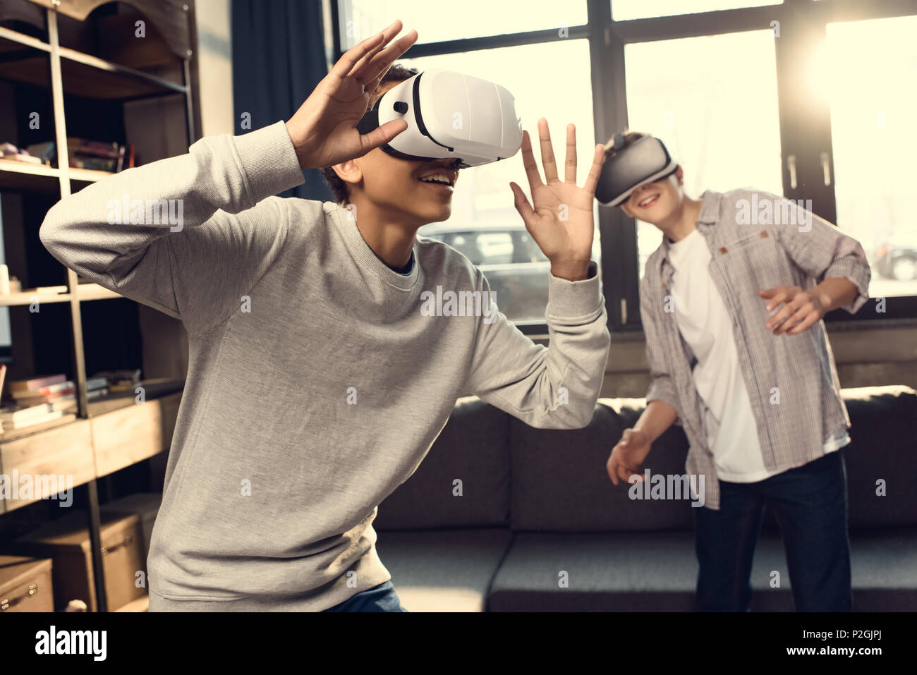 teenage boys wearing virtual reality headsets at home, teenagers
