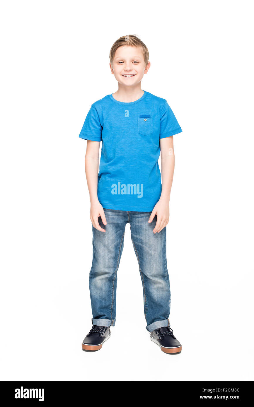 full length view of cute little boy in jeans and blue t-shirt smiling ...