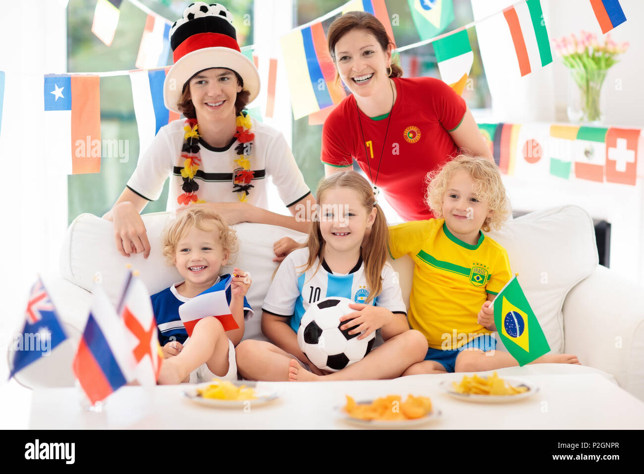 Family with children watching football game on television. Group of young  adults and kids in national tricot watch soccer match on tv. Fans cheering  a Stock Photo - Alamy