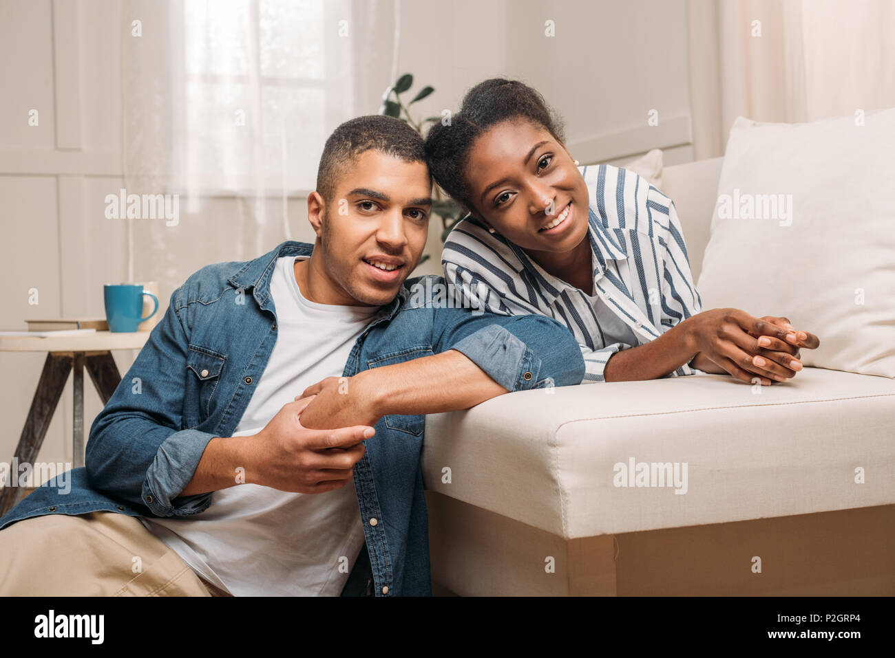 happy african american smiling couple sitting together on sofa at home ...
