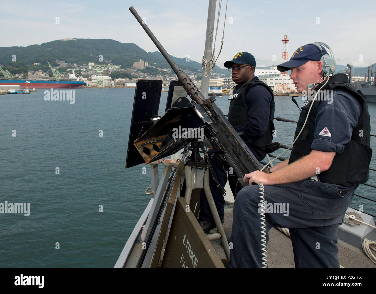 160922-N-SU278-199 SASEBO, Japan (Sept. 22, 2016) Gunner’s Mates 3rd Class Javon McCloud and Keith Oliver, assigned to the guided-missile destroyer USS Spruance (DDG 111), monitor surface vessel activity while pulling into port, Sasebo, Japan, Sept. 22, 2016. Spruance and the guided-missile destroyers USS Momsen (DDG 92) and USS Decatur (DDG 73), along with embarked “Warbirds” and “Devilfish” detachments of Helicopter Maritime Strike Squadron (HSM) 49, are deployed in support of maritime security and stability in the Indo-Asia-Pacific as part of a U.S. 3rd Fleet Pacific Surface Action Group (P Stock Photo
