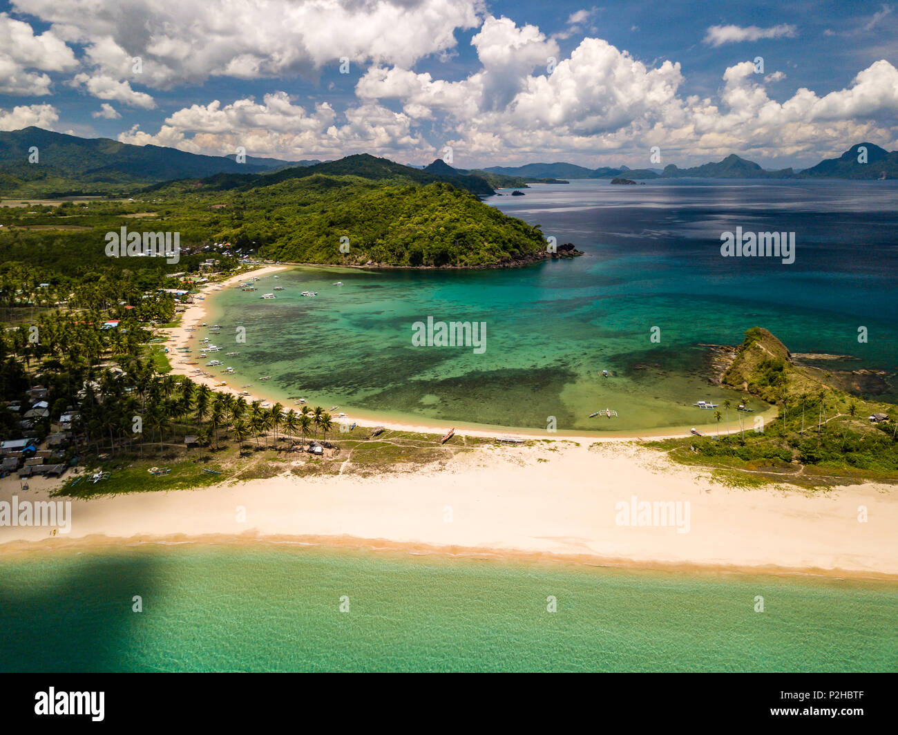 Aerial drone view of an empty, beautiful tropical beach surrounded by coral reef and greenery (Nacpan Beach, Palawan) Stock Photo