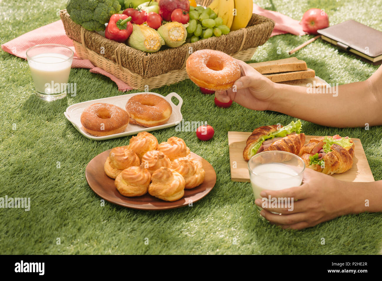 Picnic wicker basket with food, bread, fruit and orange juice on a red ...
