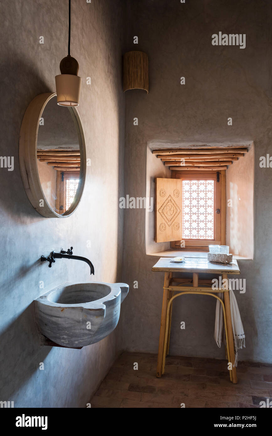 Stone mortar style basin in Berber style bathroom with terracotta floor Stock Photo