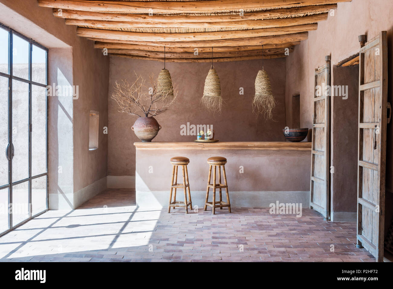 Rattan lanterns hang above counter with bamboo bar stools in bar with wood  ceiling and terracotta floor. The antique pot comes from east africa Stock  Photo - Alamy