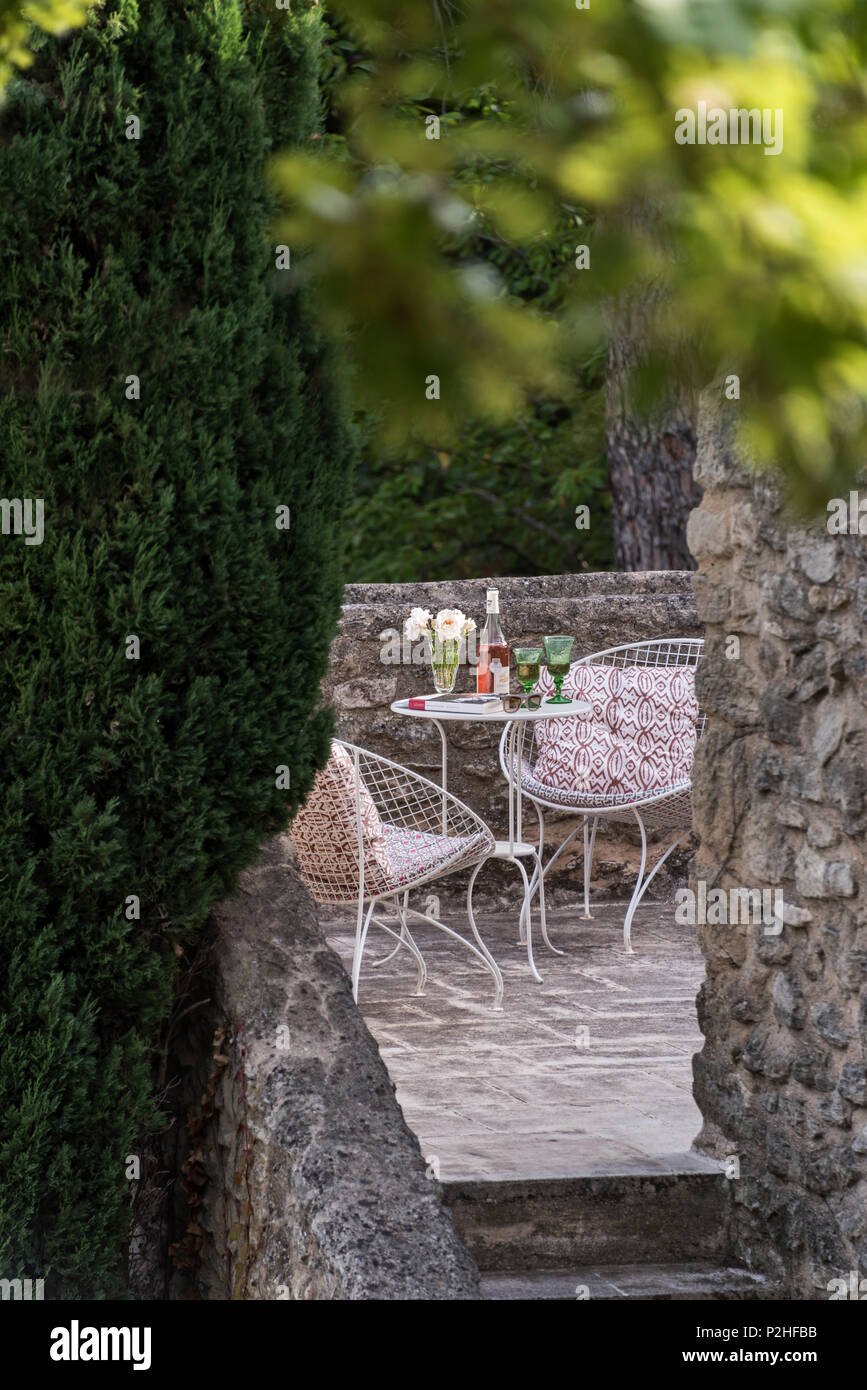 Wire mesh chairs and table on terrace of Luberon farmhouse. Stock Photo