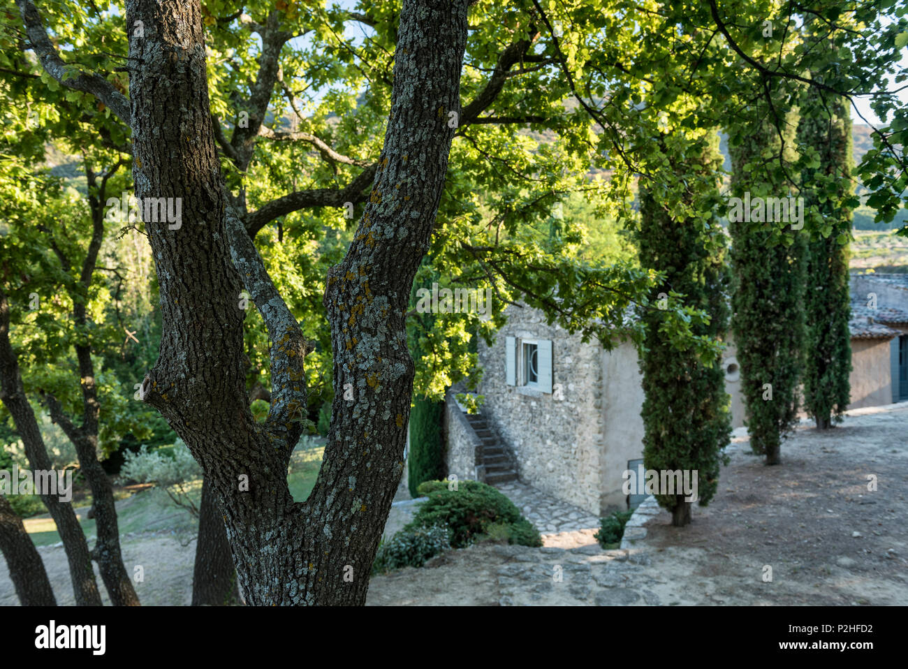 Exterior grounds of Luberon farmhouse. Exposed stone exterior architecture of Luberon farmhouse on hillside Stock Photo