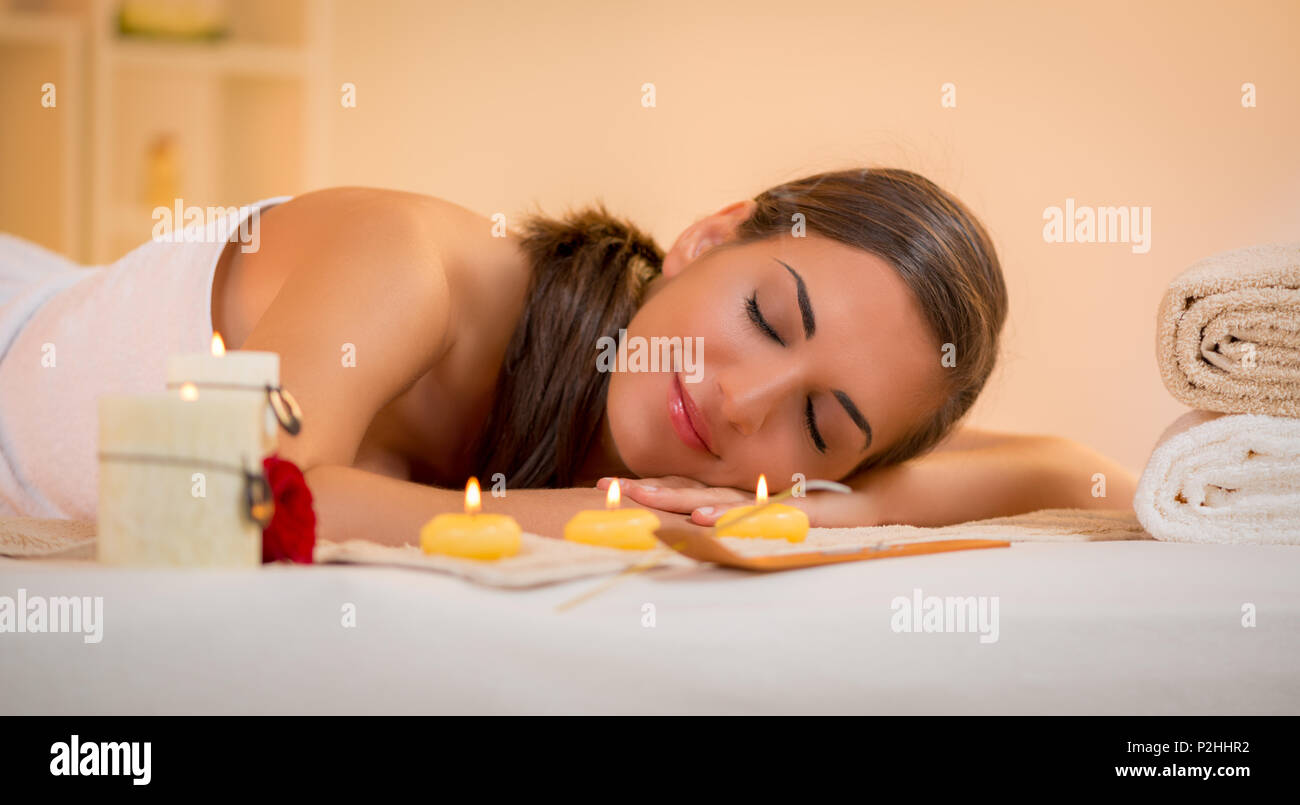 Cute young woman enjoying during a skin care treatment at a spa. Stock Photo